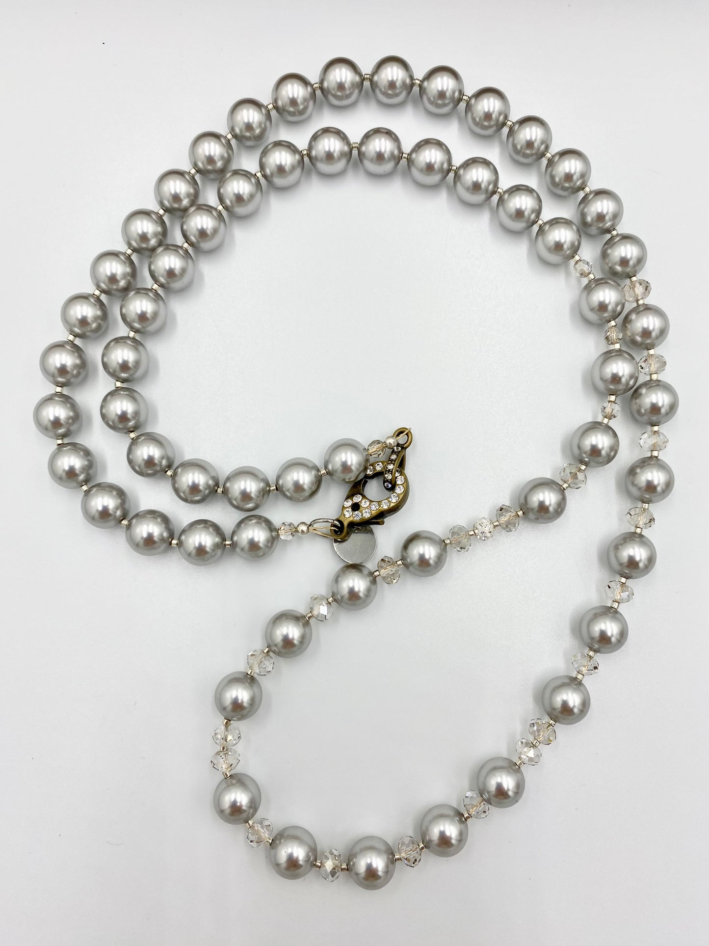 Sautoir « gris perle » argenté.
